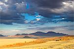 View at dusk over the magnificent desert and mountainous landscape of the Namib Rand game reserve, Namib Naukluft Park, Namibia, Africa