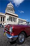 Red vintage American car parked opposite The Capitolio, Havana Centro, Havana, Cuba, West Indies, Central America