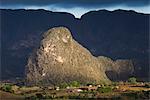 View across Vinales Valley, UNESCO World Heritage Site, from Hotel Los Jasmines in stormy weather showing one of the limestone Magotes lit by the sun against mountains in shade, Vinales, Pinar Del Rio Province, Cuba, West Indies, Central America