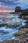 Waves crash against the rocky coast of Portland Bill at sunset. Isle of Portland, Jurassic Coast, UNESCO World Heritage Site, Dorset, England, United Kingdom, Europe