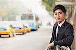 Young businessman waiting at the bus stop for the bus