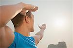 Young Muscular Man Stretching Toward the Sun