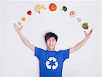 Young man with fresh fruit and vegetables, curve, studio shot