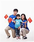 Family Portrait, one child with parents, waving Chinese flags, studio shot