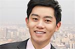 Portrait of young businessman close-up, cityscape in background