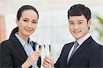 Young business man and woman toasting with champagne flutes