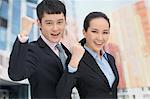 Young business man and woman cheering