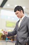 Young business man looking at flight ticket