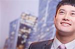 Close-up of smiling young business man looking up