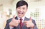 Young businessman giving the thumbs up sign, portrait