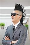 Well-dressed young man with Mohawk and sunglasses smiling