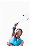 Man playing badminton, white background