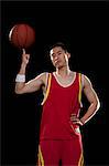 Basketball player spinning ball with one finger, black background