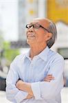 Portrait of smiling senior man, arms crossed, outdoors in Beijing