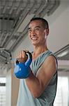 Mature man lifting weights in the gym