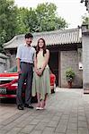 Young Couple in Front of Their Car