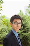 Young businessman standing in the park, portrait