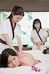 Two Masseuses Massaging One Woman