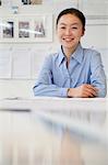 Businesswoman sitting next to the table in the office, portrait