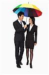 Businessman and businesswomen walking under colorful umbrella