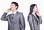 Businessman and businesswoman talking on cell phone