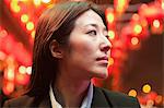 Businesswoman standing on the street, red lanterns on the background