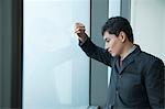 Businessman looking through window in office