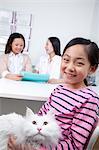 Woman and girl with pet cat in veterinarian's office