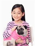 Portrait of girl holding pet pug