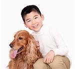 Portrait of Boy sitting next to his dog, studio shot