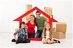 Happy family with kids moving into a new home - sitting with cardboard boxes