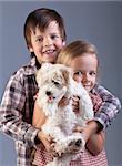 Happy kids holding their new pet - a small fluffy dog