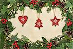 Christmas floral border with wooden bauble decorations, holly, ivy and mistletoe on old parchment paper background.