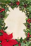 Poinsettia flower thanksgiving border with holly, ivy and mistletoe over old parchment background.