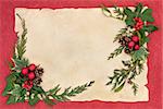 Christmas border with red baubles, holly, mistletoe, ivy, fir leaf sprigs and pinecones over old parchment and red background.