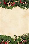 Christmas floral border with gold baubles, holly, ivy and mistletoe on old parchment paper background.