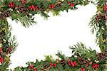 Christmas and winter floral border with natural holly, mistletoe, ivy, fir leaf sprigs and pinecones over white background.