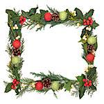 Christmas border of holly, ivy, mistletoe and red and green bauble decorations over white background.