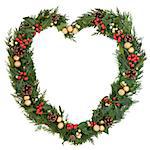 Christmas floral heart wreath decoration with gold baubles, holly and winter greenery over white background.