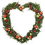 Christmas floral heart wreath decoration with gold, green and orange baubles, holly and winter greenery over white background.