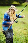 beautiful blond girl fishing in pond at autumn