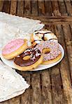 plate of  fresh multicolored  donuts  on wooden  table