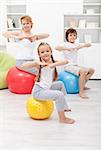 Woman doing gymnastic exercise with the kids at home