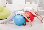Stretching exercises at home - woman and little girl on large gymnastic balls