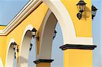 Electric lamps on a yellow wall with archs