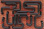 Black oil pipes on a brick wall.