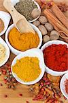 colorful spices of curry, cucrma and red pepper with seeds of anise and nutmeg on wooden table
