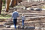 young father and his cute son walking and hiking in the woods