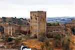 Fortified stone lookout tower with crenellations alongside a perimeter wall affording a view over the surrounding countryside and valley