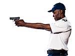 Side view of an afro American police officer aiming gun in studio on white isolated background